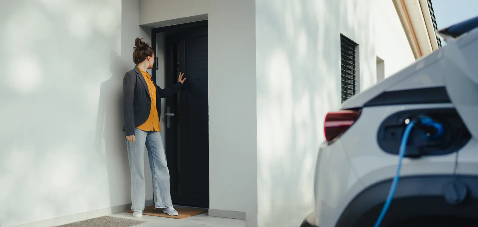 Voiture électrique en charge devant une maison