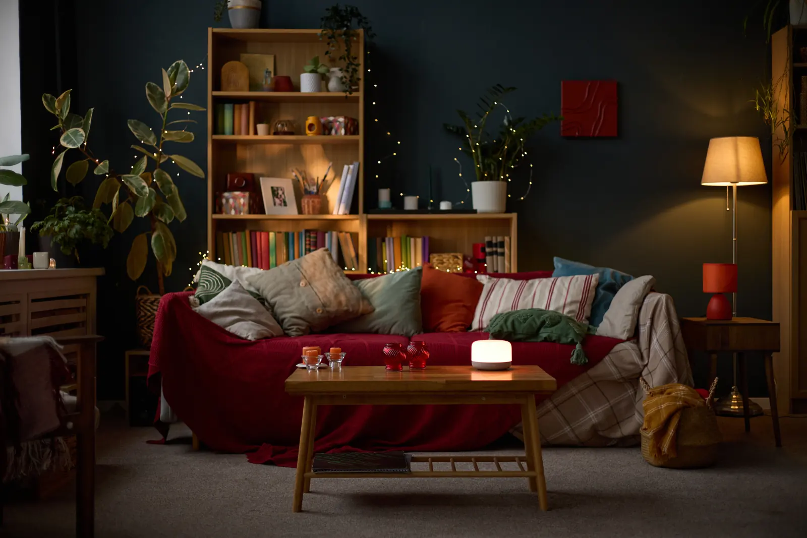 Salon chaleureux le soir, éclairé par une lampe et une guirlande